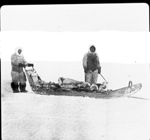 Image of Two men by lightly loaded sledge